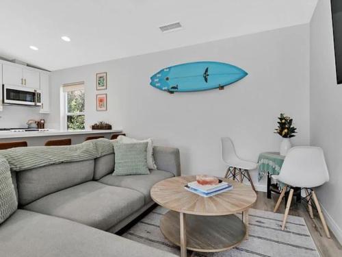 a living room with a couch and a surfboard on the wall at The Quaint Cardiff Hideaway with Pak N Play in Encinitas