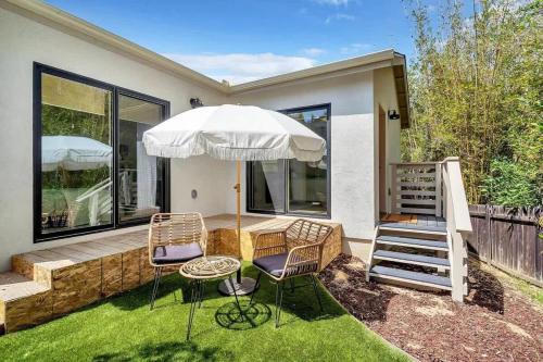 a patio with two chairs and an umbrella at The Quaint Cardiff Hideaway with Pak N Play in Encinitas