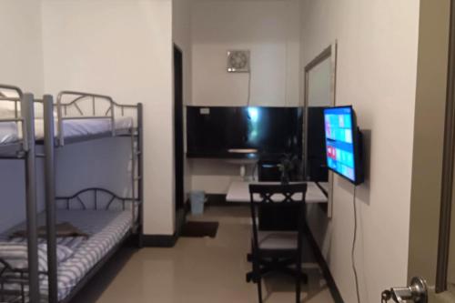 a room with two bunk beds and a television at Hotel Villarte in San Fernando
