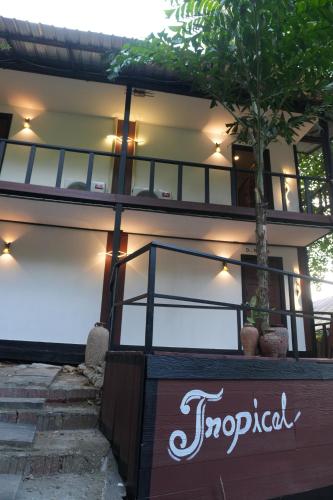 a building with a palm tree in front of it at Tropical Hostel in Phi Phi Don