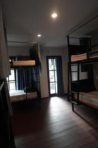 a room with several bunk beds and a window at Tropical Hostel in Phi Phi Don