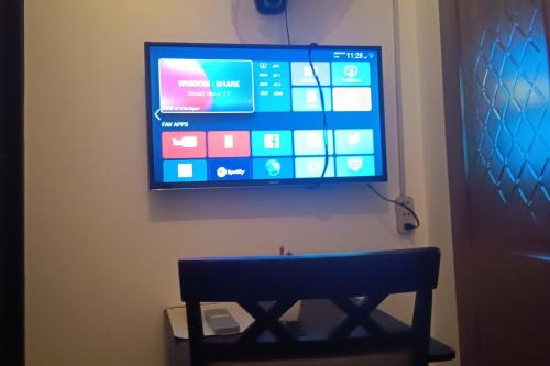 a flat screen tv hanging on a wall with a bench at Hotel Villarte in San Fernando