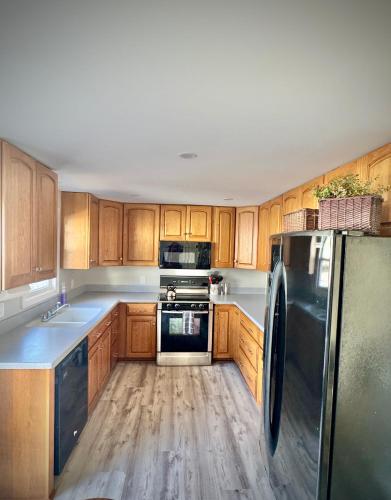 a kitchen with wooden cabinets and a stainless steel refrigerator at Londontowne Hideaway in Annapolis