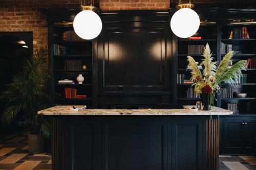 a bar with two sinks in a room with books at Garden District Hotel in New Orleans