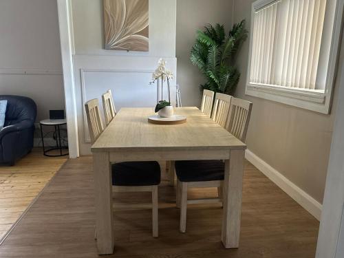 a dining room table with chairs and a table and a table and chairsktop at Stylish House 8mins walk to Figtree Grove in Figtree