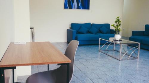 a living room with a table and a blue couch at Departamento completo, facso in Cuatro Hermanas