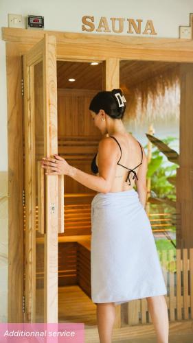 a woman is standing in front of a sauna at AMAN Villas & SPA in Gili Air