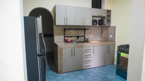 a kitchen with white cabinets and a refrigerator at Departamento completo, facso in Cuatro Hermanas