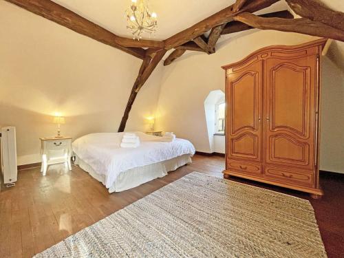 - une chambre avec un lit et une grande armoire en bois dans l'établissement Charmante Bergerie avec Piscine Privée à Trémolat - FR-1-824-7, à Trémolat