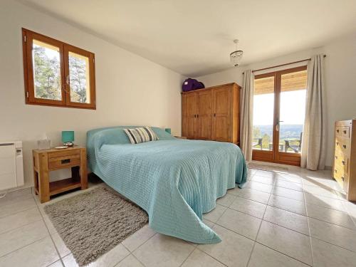 une chambre avec un lit avec une couverture bleue dans l'établissement Maison plain-pied avec piscine privée au cœur du Périgord - FR-1-824-18, à Tursac