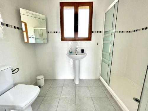 une salle de bain avec un lavabo, des toilettes et une douche dans l'établissement Maison plain-pied avec piscine privée au cœur du Périgord - FR-1-824-18, à Tursac