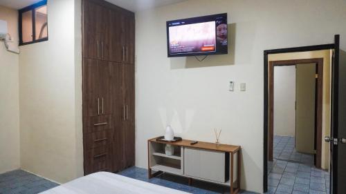 a bedroom with a tv on the wall and a bed at Departamento completo, facso in Cuatro Hermanas