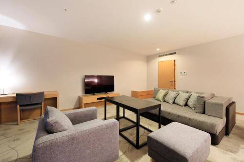 a living room with a couch and chairs and a tv at Hakone Hisui in Hakone