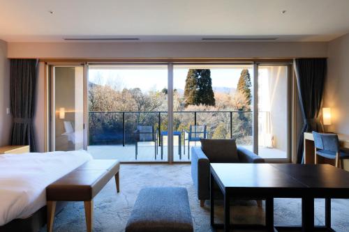 a hotel room with a bed and a large window at Hakone Hisui in Hakone