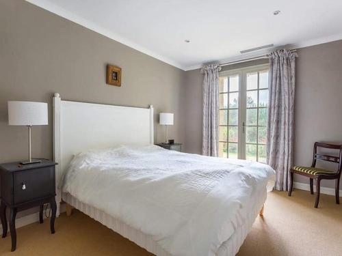 une chambre avec un grand lit blanc et une fenêtre dans l'établissement Maison privée avec piscine chauffée, 10 pers., Saint-Chamassy - FR-1-824-15, à Saint-Chamassy