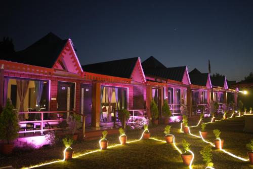 ein Gebäude mit rosafarbenen Lichtern in der Nacht in der Unterkunft Sol Glow Resort in Bhowāli