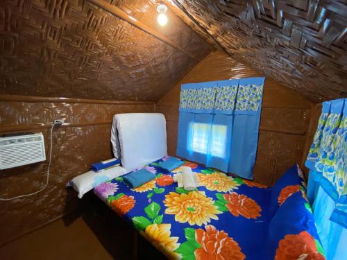 a small room with a bed with flowers on it at Eco Park - Albur Rental Properties in Alburquerque