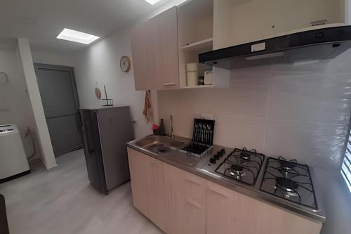 a kitchen with a stove and a sink and a refrigerator at GURUS FR | Apartamentos cerca Olaya, Megacable, Terminal in Pereira