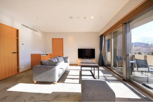 a living room with a couch and a tv at Hakone Hisui in Hakone