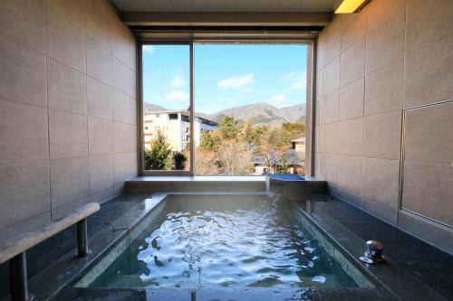a bathtub with a large window in a room at Hakone Hisui in Hakone