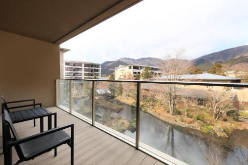 a balcony with a bench and a view of a river at Hakone Hisui in Hakone