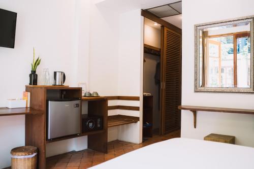 a room with a bed and a television and a window at Le Sen Boutique Hotel in Luang Prabang