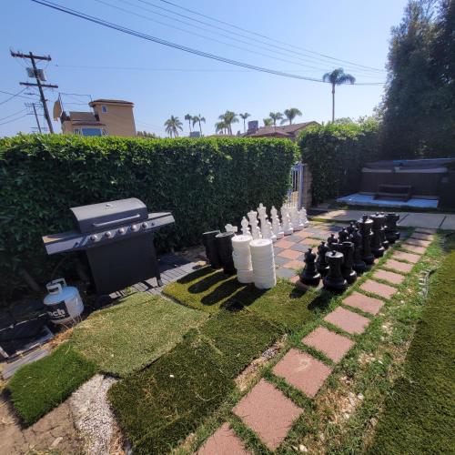 a backyard with a chess board and a grill at 3 bedroom 2 bath home with Jacuzzi near Beverly Hills, wi-fi, Jacuzzi, Roku, BBQ, giant games family fun in Los Angeles