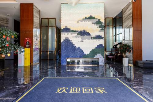 a lobby with a large mural in a building at Dujiangyan Yuandong Yaju Hotel in Dujiangyan