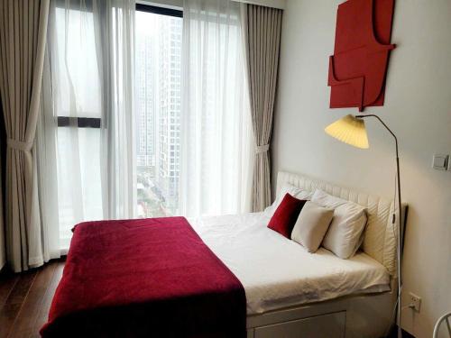 Un dormitorio con una cama con una manta roja. en Max Housing, en Phú Thú