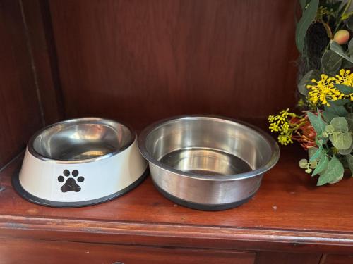two metal bowls sitting on top of a wooden shelf at Misty Valley Cottage in Mapleton