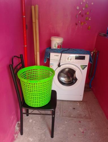 a laundry room with a washing machine and a green basket at CHEZ ALIZHIA in Nuku Hiva