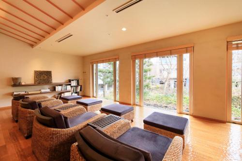 a waiting room with chairs and tables and windows at Hakone Hisui in Hakone
