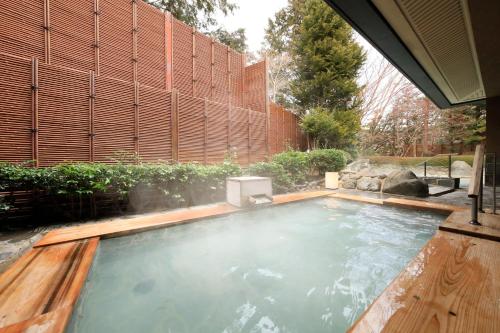 a swimming pool in a backyard with a wooden fence at Hakone Hisui in Hakone