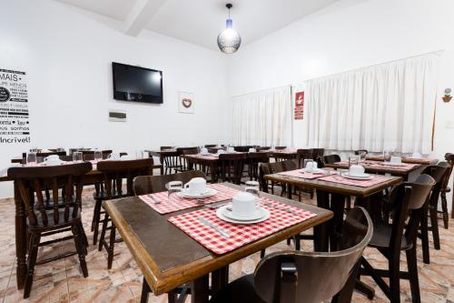 a dining room with wooden tables and chairs at VELINN Pousada Casa de Campos Mountain House in Campos do Jordão