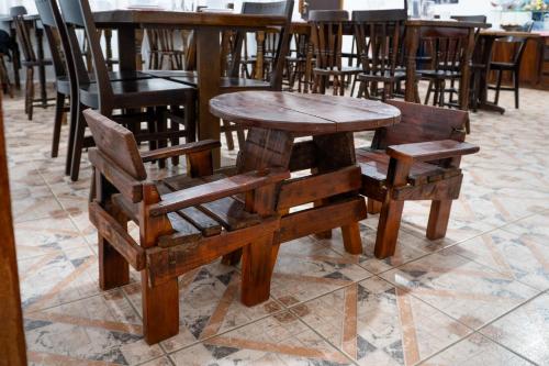 a wooden table and two chairs and a wooden table and chairs at VELINN Pousada Casa de Campos Mountain House in Campos do Jordão