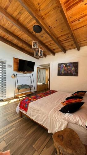 a bedroom with a large bed with a wooden ceiling at SENDERO REAL Mazamitla 3 in Mazamitla