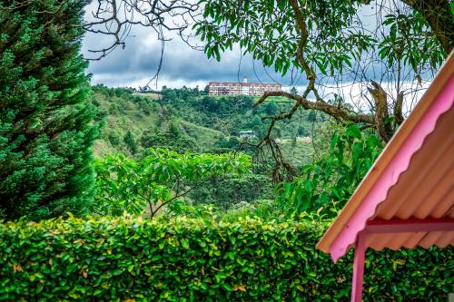 a view of a hill with a building in the distance at VELINN Pousada Casa de Campos Mountain House in Campos do Jordão