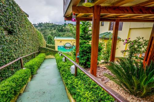 a walkway in a garden next to a building at VELINN Pousada Casa de Campos Mountain House in Campos do Jordão