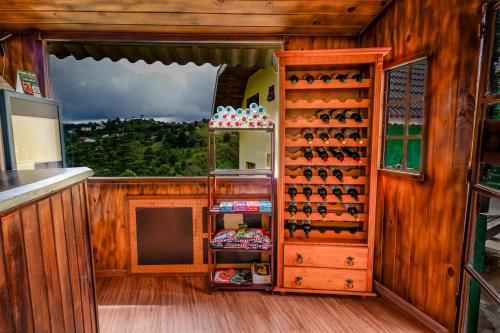 a room with a wall of wine bottles at VELINN Pousada Casa de Campos Mountain House in Campos do Jordão