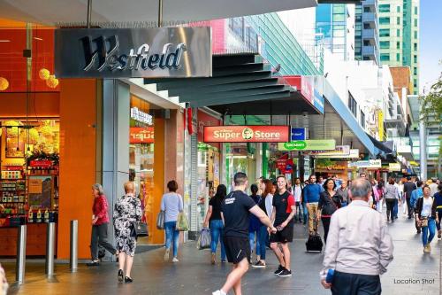 a group of people walking down a busy city street at Serain Chatswood Central in Sydney