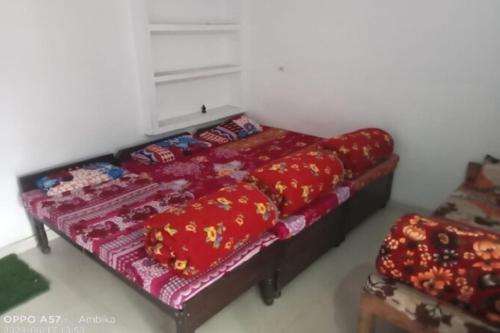 a bedroom with a bed with red sheets and pillows at Hotel Shri Kedar Mangalam By StayApart in Phata