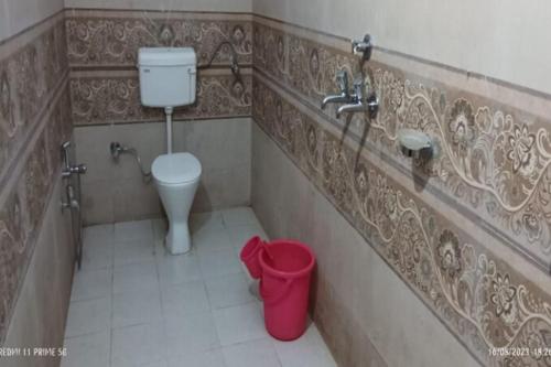 a bathroom with a toilet and a sink and a trash can at Hotel Shri Kedar Mangalam By StayApart in Phata