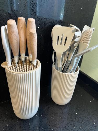 three cups filled with wooden utensils on a counter at Lavender Villa Marc Residence Bukit Mertajam in Bukit Mertajam