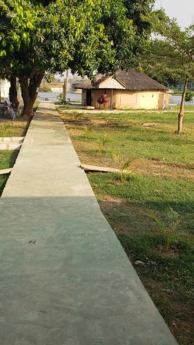 a concrete path in a park with a building at Volta Safari Guest House in Atimpoko