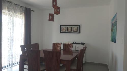 a dining room with a wooden table and chairs at villa le manguier in Cap Malheureux