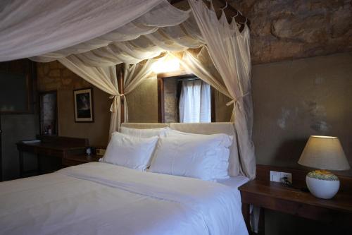 a bedroom with a white bed with a canopy at 温岭海山生活石屋民宿 in Shangma