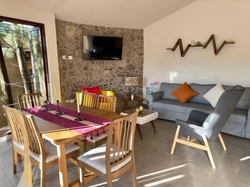 a living room with a table and chairs and a couch at Loft Kaela en, Val'Quirico in Santeagueda
