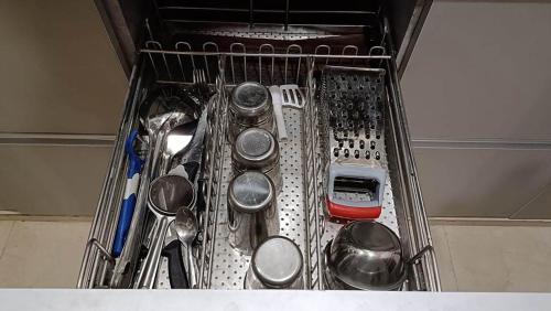 a metal strainer with utensils in a drawer at Homestay at Rishikesh - 1BHK Apartment in Rishīkesh