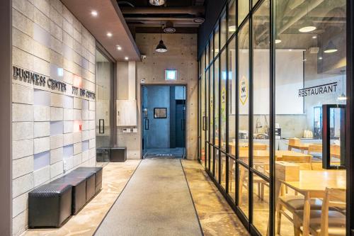 a restaurant hallway with tables and a blue door at Gong-Ju TouristHotel INK in Gongju
