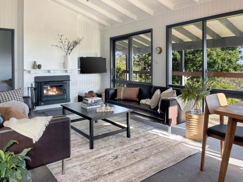 a living room with a couch and a fireplace at Clifftop cottage escape with breathtaking views in Wentworth Falls